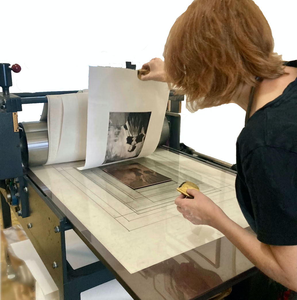 Laurence de St Martin utilise une presse d'impression, soulevant une feuille de papier avec une image imprim&eacute;e.